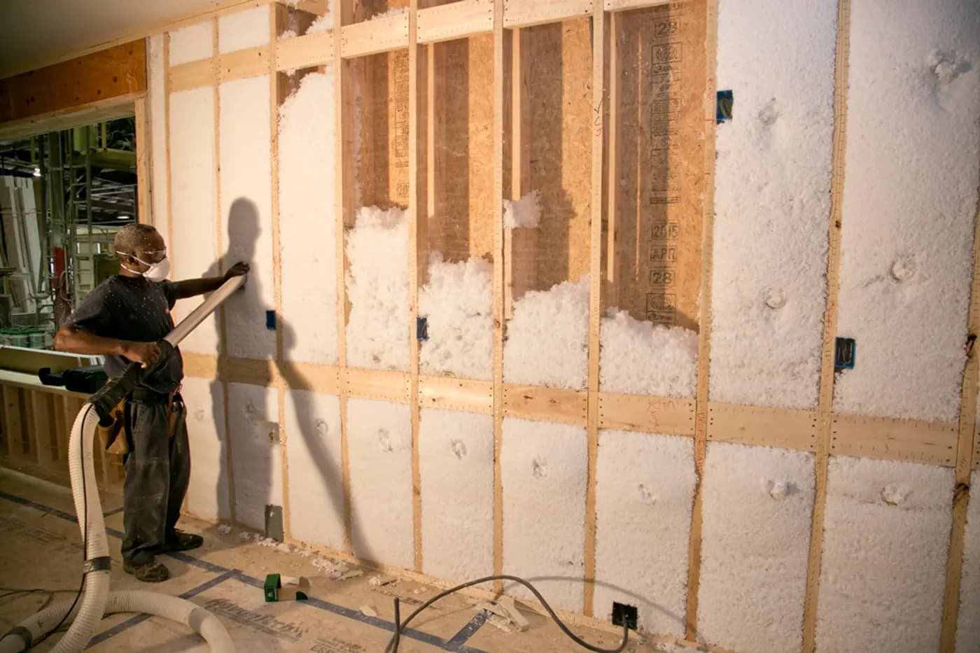 A Beracah crew member spraying insulation into a stud bay inside the Greenwood factory.