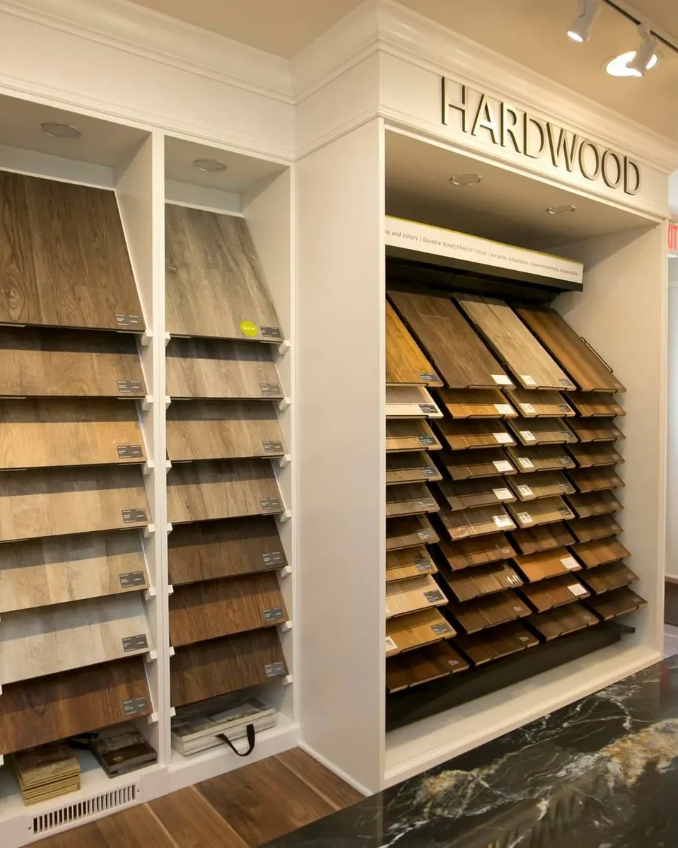 Racks of hardwood flooring samples pulled out along a wall in the Beracah design studio.