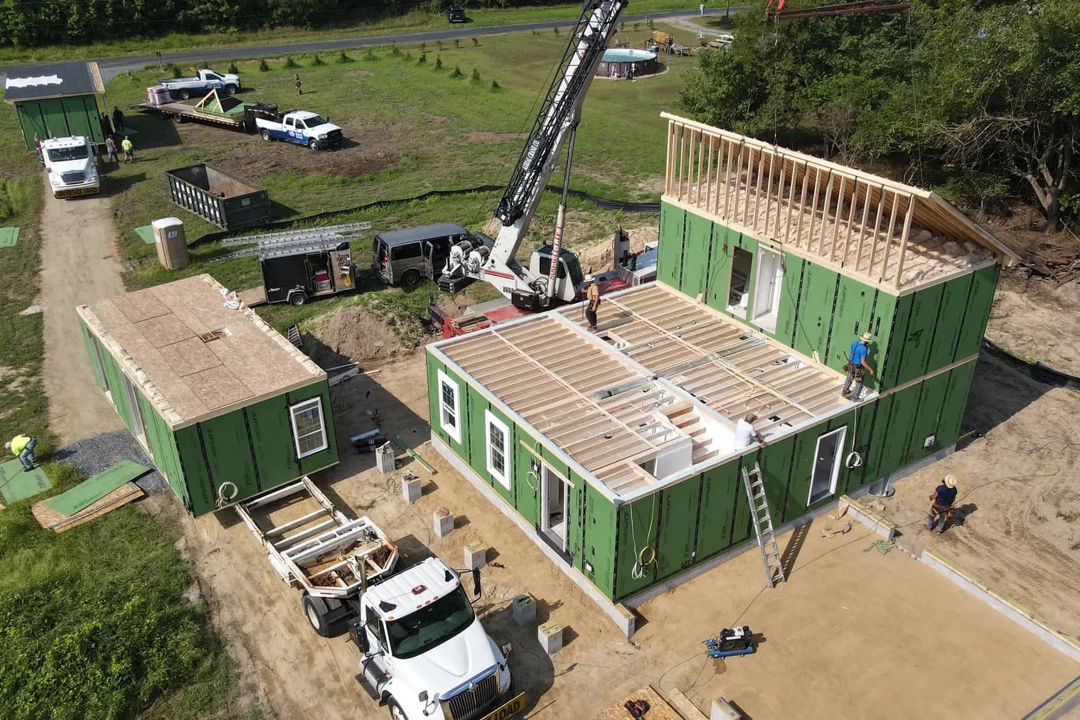 Aerial view of two Beracah modules being craned onto a new foundation on an open Delmarva lot.