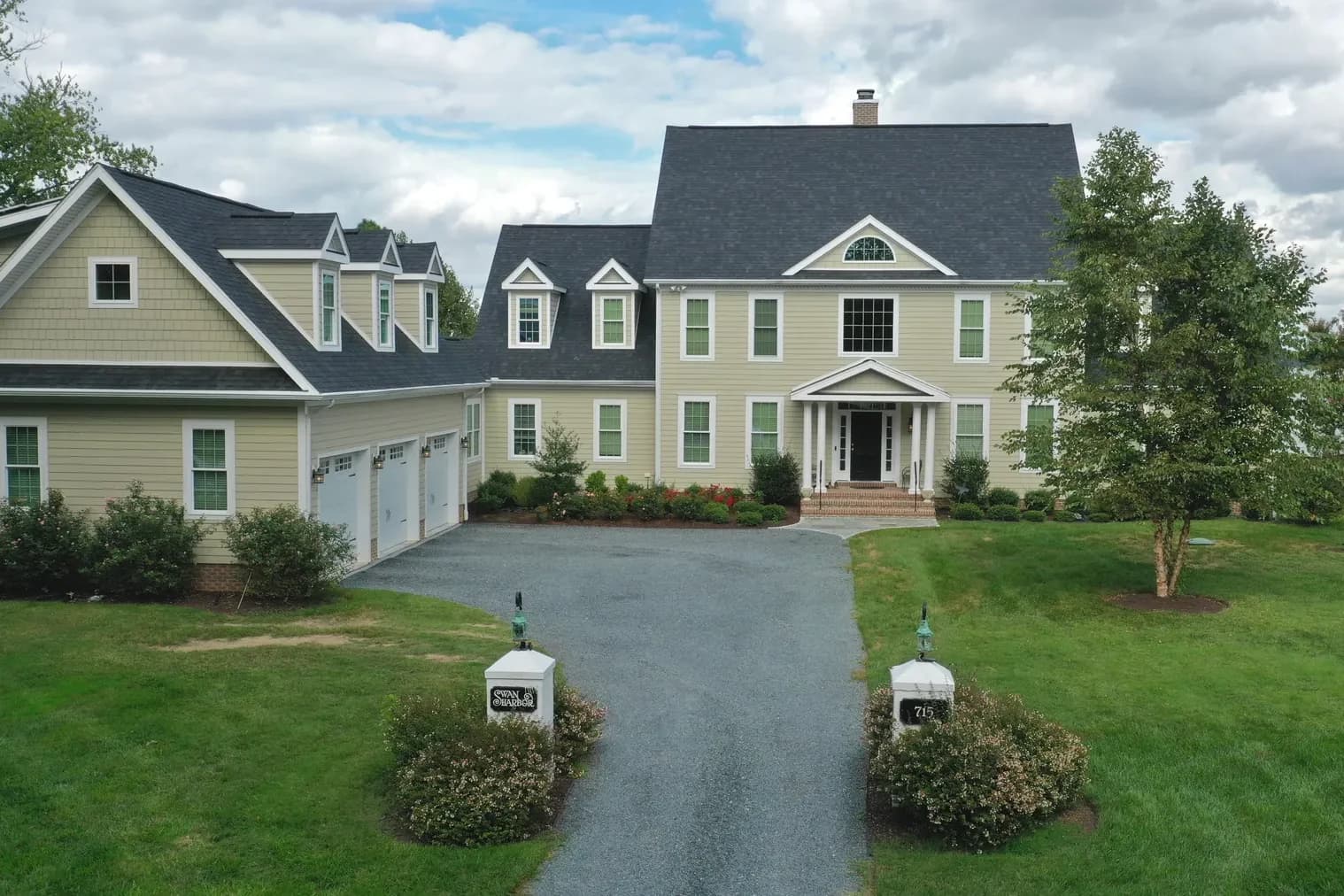 A finished two-story Beracah home at the end of a long drive, with mature trees and open lawn.